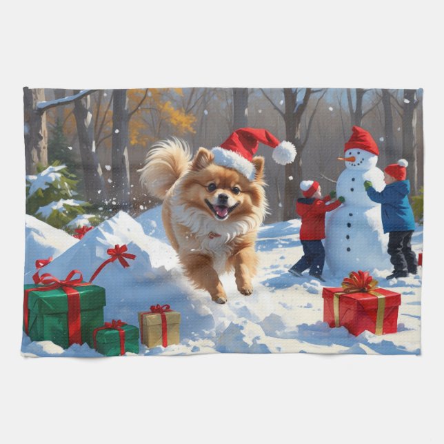 Pomeranian springer i snö med julhatt kökshandduk (Horisontell)