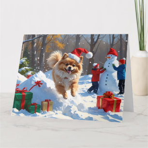 Pomeranian springer i snö med julhatt kort