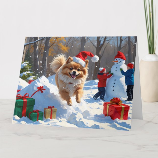 Pomeranian springer i snö med julhatt kort (Framsida)