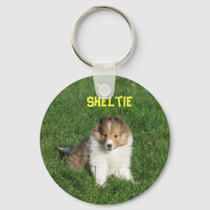 Pretty sheltie puppy sitting in grass keychain nyckelring