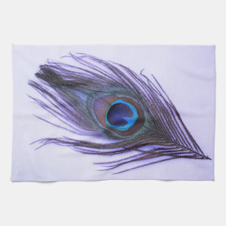 Purpurfärgad påfågelfjäder på purpurfärgad kökshandduk