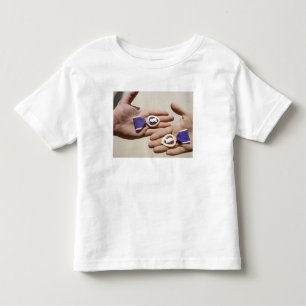 Purpurfärgade hjärtamottagare visar deras medalj tee shirt