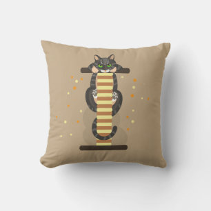 Randig katt som leker med röd låda / kattskräpare kudde