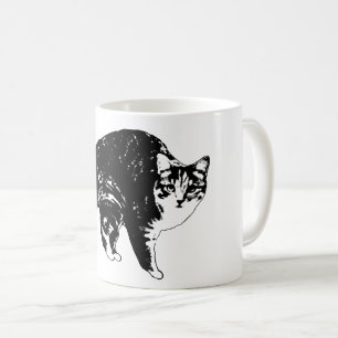 Randig katt under hösljus kaffemugg