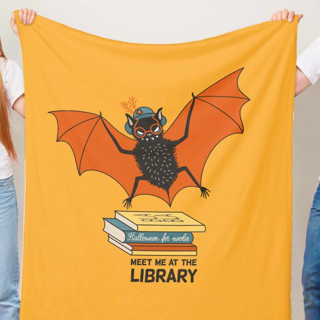 Reading Bat | Whimsical Librarian with Books Fleecefilt (close up on bat librarian blanket in orange yellow and blue held in hands)