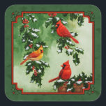 Red Cardinals och Holly Grönt Fyrkantigt Klistermärke<br><div class="desc">Ett par manliga och hona norrut kardinaler i ett holly träd,  medan en tredje kardinal sitter på ett träträ av basket fyllt med nyplockat grovt löv och bär. Allt på en festlig grönt. Bilden skapades från en ursprunglig oljemålning av Crista Forest.</div>