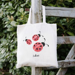 Red Watercolor Ladybugs Personlig Tygkasse<br><div class="desc">Den här väskan har tre söta ladybuggar i mjuka röda och träkolsvattenfärger. Koordinerar vår samling av Watercolor Ladybug-kläder och tillbehör. Anpassa till namn om du vill - gör en perfekt fest för flickors födelsedagsfester!</div>