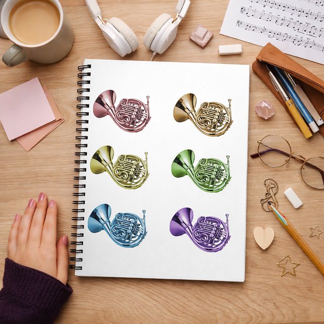 Regnbågsfranska hornuppställning anteckningsbok (A notebook with a rainbow french horn pattern.)
