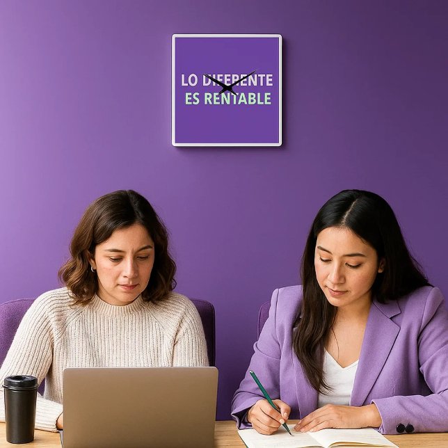 Reloj de pared “Lo diferente es rentable” – Mensaj Fyrkantig Klocka (dos mujeres trabajando en una oficina acogedora y detrás de ellas, un reloj diferente. )