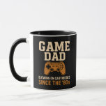 Retro Game Pappa, 80-talskassett Vibes Mugg<br><div class="desc">Firar klassiskt spel med det fet "Game Pappa - Blowing on Cartridges" sedan 1980-talet. Den här nostalgiska konsten har en olycklig vintage-stil-styrenhet i svart bakgrund och är perfekt för pappor som växte upp i den gyllene speltiden. En humoristisk hyllning till faderskapet och den gamla spelstilen i skolan.</div>