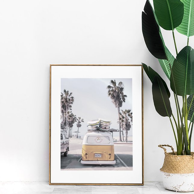 Retro Van med surfboard på Poster i kuststranden (Retro Van with Surfboards on Coastal Beach Poster in a white frame next to large plant.)