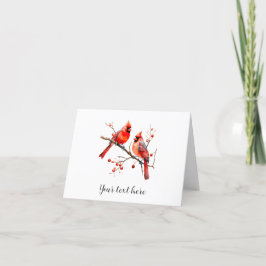 Röda kardinalfåglar på gren av järnek helgkort