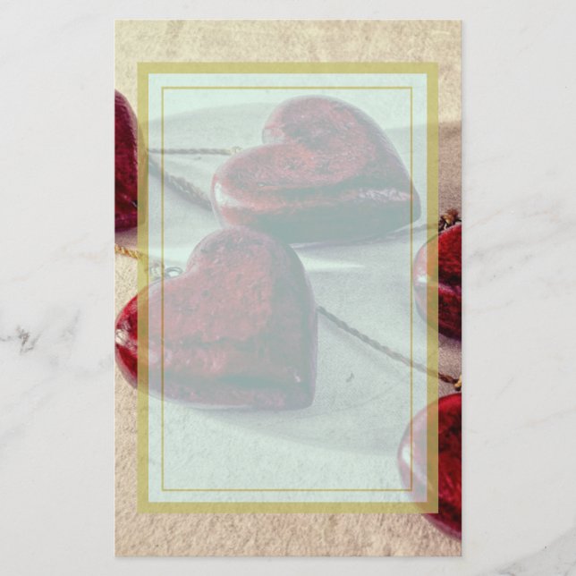 Röda trähjärtor som tillsammans binds på en brevpapper (Framsida)