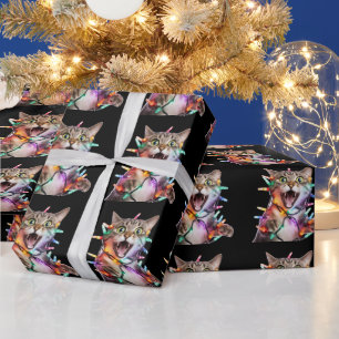 Rolig katt intrasslad i julgransbelysning presentpapper