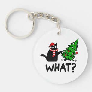 Rolig svart katt present som knuffar julgran över 