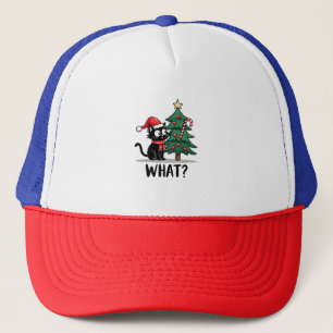 Rolig svart katt present som knuffar omkull julgra keps