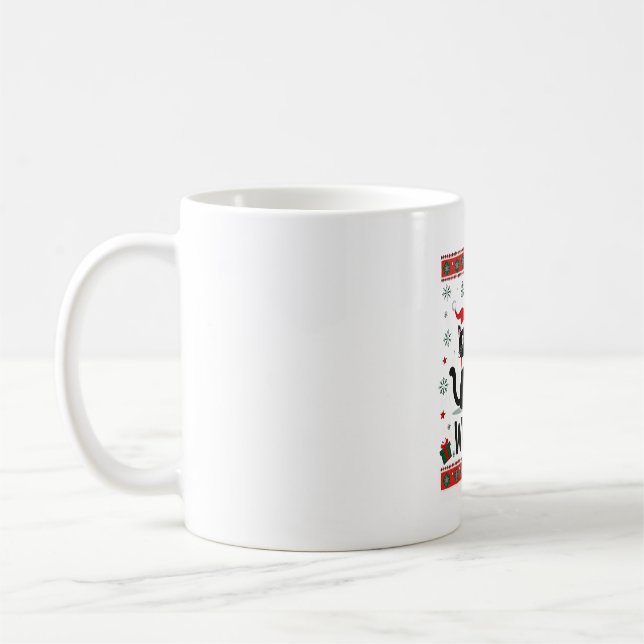 Rolig svart katt som puttar julgran ful kaffemugg (Vänster)