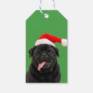 Rolig svart mops i jultomtehatt med tungan ute jul presentetikett