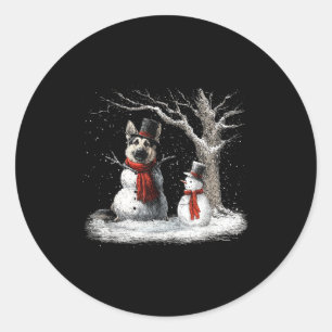 Rolig tysk schäferhund i julgranen i snö runt klistermärke