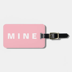 Rosa bagagemärke med "Min" skriven på det Bagagebricka