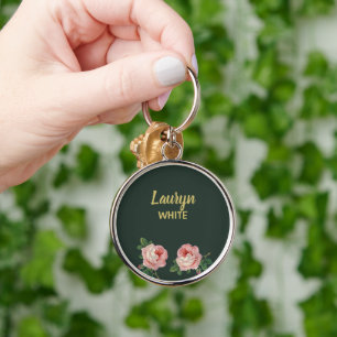 Rosa blomma och löv på mörk grönt rund silverfärgad nyckelring