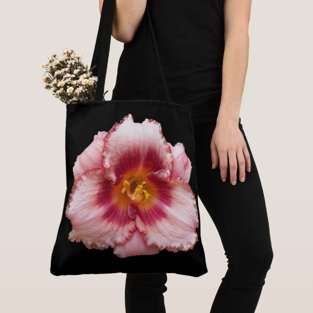 Rosa daglilja blommar på svart blommönster tygkasse (Närbild)