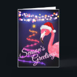 Rosa Flamingo Festive Tropical Beach-jul Helgkort<br><div class="desc">Det här århundradets hälsningskort från Greetings-tropisk strand har en rosa flamingo med röd och vit julhatt. Det finns festive helgdag string ljus och Ribbon och Stars Julgran. Inuti Hälsning ~ "varmaste Önskemål från våra Helgdag till era". ^</div>
