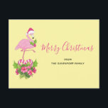 Rosa flamingo i tomteluva, nyckfull jul helg vykort<br><div class="desc">Julkort med en tropiskt tematiserad julflamingo som bär rosa tomteluva. Under fötterna finns en bukett med sockerrör och vackra tropiska blommor och rosa bär. En liten gren julgransslingor på bröstet.</div>