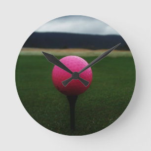 Rosa golfboll på en berggolfbana rund klocka