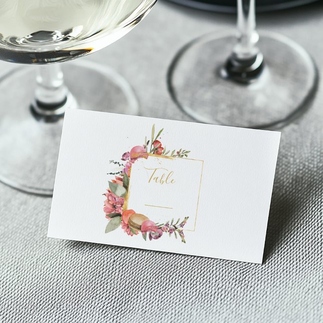Rosa löv, blommor och makaroner bordsnummer placeringskort (Colorful floral and macaron frame on a white and gold guest wedding name place card)
