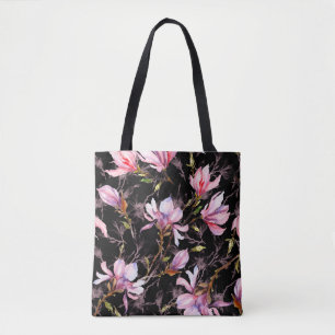 Rosa magnolia-blommor på en mönster tygkasse