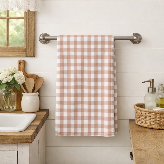 Rosa och vit gingham-rutig lantstugestil kökshandduk (A kitchen towel with a pink and white gingham plaid.)