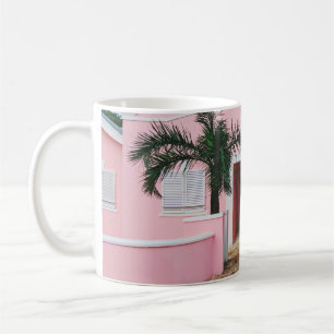 ROSA OCH VITKONCRET HUS NÄRA GRÖNTEN TRÄD UND KAFFEMUGG