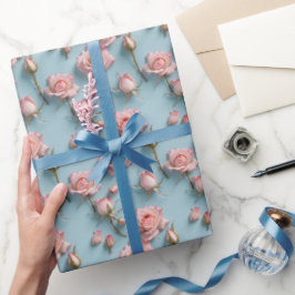 Rosa rosor utspridda över ljusblå bakgrund presentpapper
