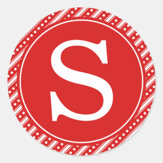 Rött julomslag förseglingsstift med monogram runt klistermärke