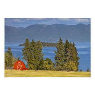 Rött lada sitter längs den natursköna Flathead Lak Fototryck