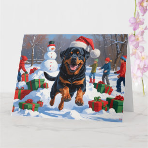Rottweiler springer i snö med julhatt kort