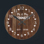 Rustic Barn Wood Plank Bröllop Rund Klocka<br><div class="desc">Bröllop-väggklocka med en rustik träbakgrund. Anpassa den rustiska lingklockan med ett par efternamn och bröllop datum. Gör en unik gåva till nygifta eller till husuppvärmning.</div>