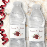 Rustic Burgundy Red &  Rosa ros Bröllop Vattenflaskor Etikett<br><div class="desc">Dessa vattenflaskor kommer att göra bröllop firande ännu mer speciellt. De har en design som är enkel men ändå elegant med ett kluster av vattenfärgsfärgat ro i burguddiga,  röda och  rosor. Det finns ett skrivbrev för bröllop parets namn och ett ställe för att ange bröllop-datumet.</div>