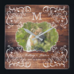 Rustic Woodland Bröllop Photo Wood Panel Monogram Fyrkantig Klocka<br><div class="desc">Fira bröllop med den här roliga, trätemade, engramsbildande fotodesignen i ram. Elegant vit ram med finare hörn av löv, blommor, hjärtan och rutor på träpanelens bakgrund väntar på ditt favoritfotografi av bröllop. Byt ut exempelfotot och text mot en egen personlig. Gör en underbar gåva till Bröllop, årsdag, Förlovning, födelsedag och...</div>