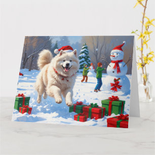 Samojed springar i snö med julhatt kort