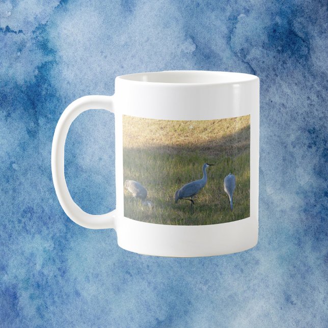 Sandhill Cranes Bird Grazing Photo Kaffemugg (A mug with a photo of three sandhill crane birds grazing in the grass.)