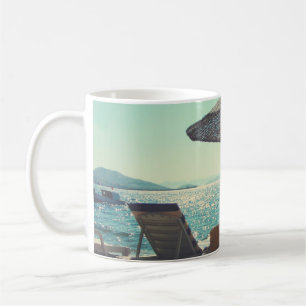 Sandy strand på en solig eftermiddag med parasoler kaffemugg
