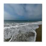 Santa Monica Beach i fallet. Kakelplatta<br><div class="desc">Ett fredligt landskap fångat i Santa Monica Beach,  Los Angeles. Mjukt vågar,  varmt ljus och bred kom i himmel tillsammans i detta lugnande foto - perfekt för att lägga till en liten bit kustfrid i ditt utrymme.</div>