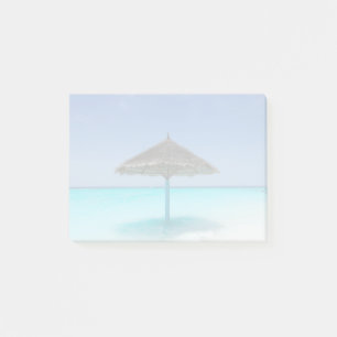 Scenisk tropisk strand med tunn paraply post-it block