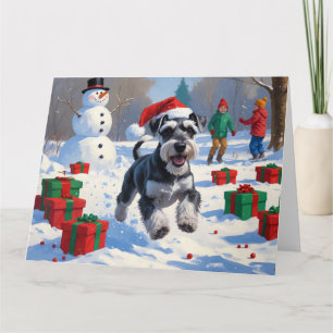Schnauzer springar i snö med julhatt kort