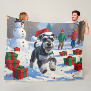 Schnauzer springer i snö med julhatt fleecefilt