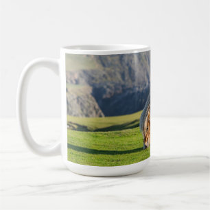 Shetlandponny på betesmark nära höga klippor kaffemugg
