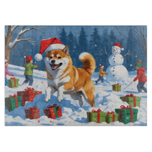 Shiba Inu springer i snö med julhatt
