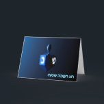 Shiny Blue Dreidel Helgkort<br><div class="desc">En moderniserande,  metallisk,  blå dröm mot en mörk,  nattlig bakgrund. Två av hebreiska brev hittades på en dröm,  nunna och shin,  glöd. Den hebreiska text som lyder "Chag Chanukkah Sameach" (Lycklig Hanukkah) förekommer också i blått och vitt ljus.</div>